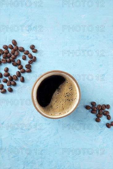 Coffee cup and beans, shot from above on a blue background with a place for text, Food photography
