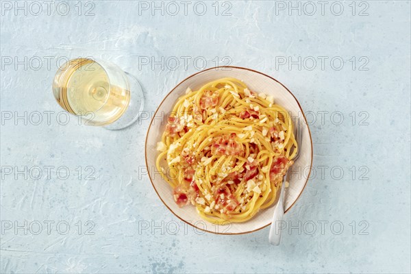 Carbonara pasta dish, traditional Italian spaghetti with pancetta and cheese, with wine, and a