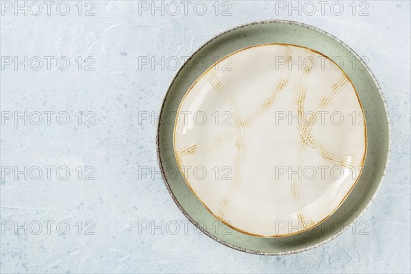 An empty plate with a gold rim, shot from above on a slate background with a place for text, Food