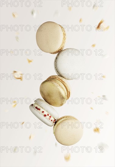 White, yellow, gold macaron cookies. Colorful, sweet small French macaroon cakes. Light beige