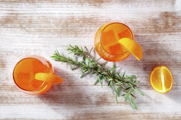 Orange cocktails with rosemary, overhead flat lay shot on a wooden background, Food photography