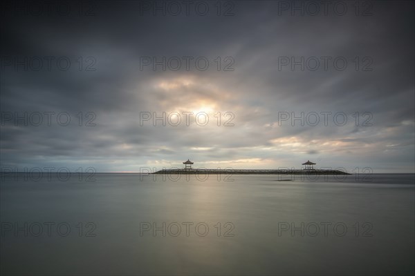 Beautiful seascape in the morning. Tropical sandy beach with breakwater and reflection of the sky