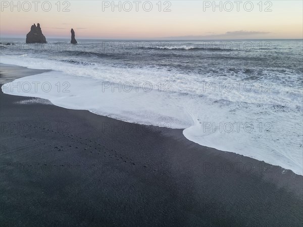 Aerial drone view of Reynisfjara black sand beach at sunset in Iceland