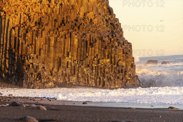 Beautiful on the black sand beach of Reynisfjara at sunset in Iceland