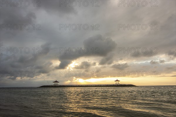 Beautiful seascape in the morning. Tropical sandy beach with breakwater and reflection of the sky
