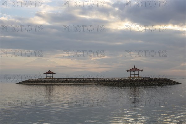 Beautiful seascape in the morning. Tropical sandy beach with breakwater and reflection of the sky