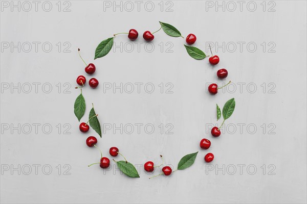 Gray concrete flat lay with big sweet cherries on table background. Top view on huge, massive