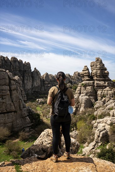 Woman looking at limestone rock formations in El Torcal de Antequera nature reserve, in Spain