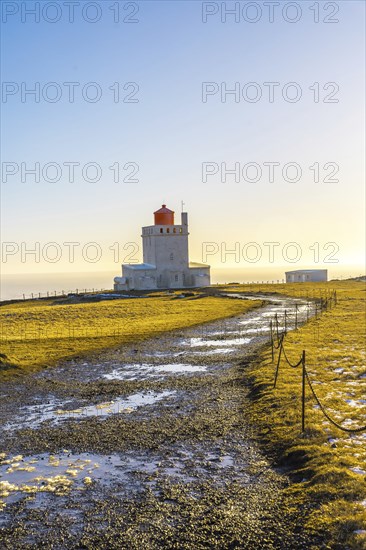 Trail leading to the famous lighthouse at sunset on Dyrholaey beach in Iceland in the cold winter,