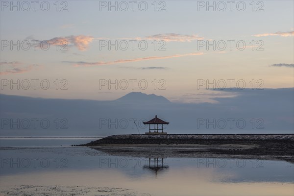 Beautiful seascape in the morning. Tropical sandy beach with breakwater and reflection of the sky