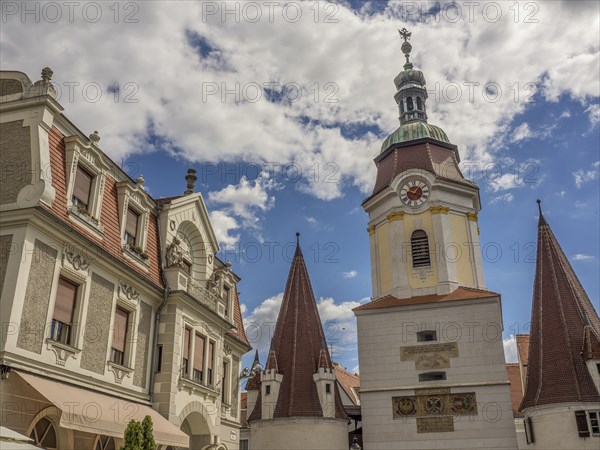 Historic buildings with church tower and spires, under a blue sky with clouds, Dürnstein, Wachau,