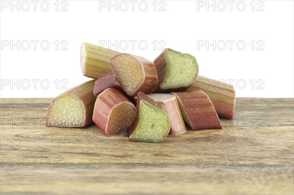 Variety of rhubarb stalks of varying colors from pale green to deep red on wooden cutting board