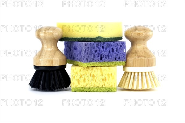 Three sponges, each a different color purple, yellow, and blue and two brushes with wooden handles