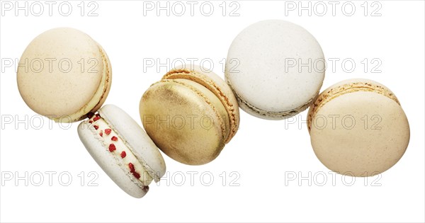 Isolated on white background white, yellow, gold macaron cookies flying, falling in motion or