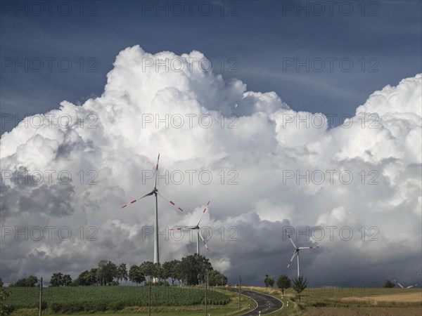 Road between Töpen and Mödlareuth with wind turbines and massive clouds behind them