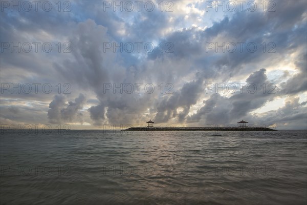 Beautiful seascape in the morning. Tropical sandy beach with breakwater and reflection of the sky