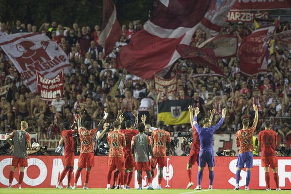 Football match, the team of FC Bayern Munich with raised hands in the curve after the victory to
