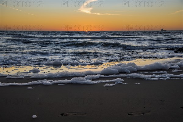 Den Helder, Netherlands. January 2022. Setting sun on the beach of Den Helder, Netherlands.