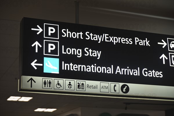 Airport signage directing passengers to parking areas and domestic flights