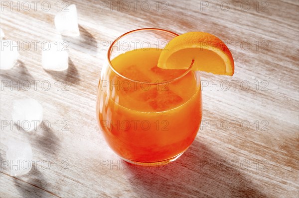 Orange drink on a wooden background, fresh pressed juice with a fruit slice and ice, Food