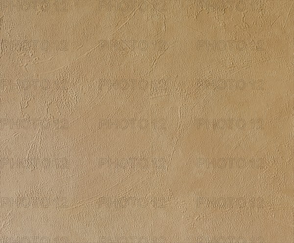 Light beige, roughly plastered house wall as full-format background