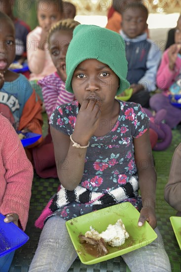 Child eats rice from plastic plate, Preschool for orphans, Katutura district, Windhoek, Khomas