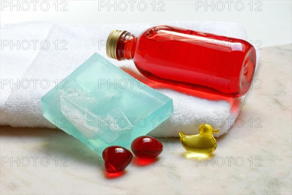 Soap and bath pearls, liquid soap, bar of soap with sea salt crystals, towel, bath additive