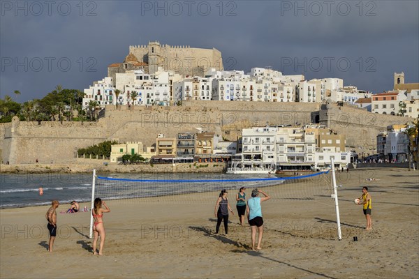 Beach volleyball players on the beach of Peñíscola, in the background the old town, province