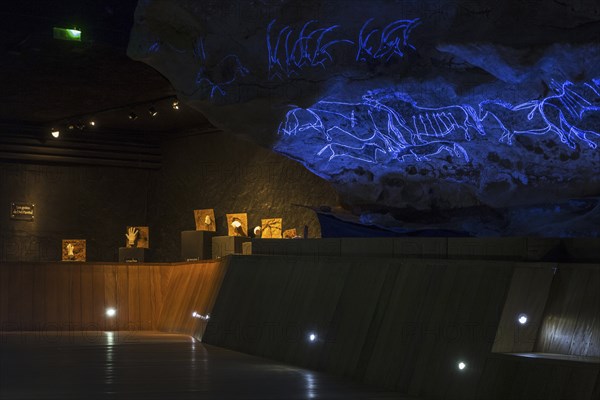 Replica of part of the Lascaux cave showing with black light prehistoric animals incised in the