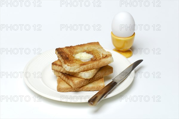 Toast, melting butter, breakfast egg, toast, plate, knife, egg cup, egg
