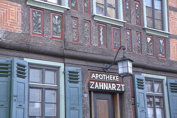 Historic half-timbered house with flowers as wall painting and wood carving with inscription
