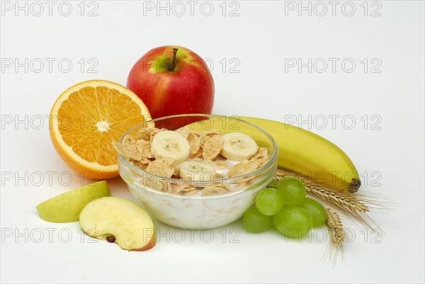 Muesli with milk in shell, apple, banana, orange, grapes, muesli