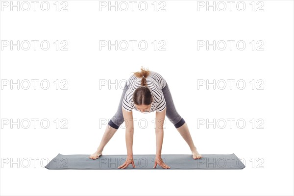 Pregnancy yoga exercise, pregnant woman doing yoga asana prasarita padottanasana A Wide-Legged