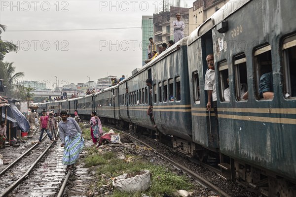 A train passes through an informal settlement built close to a railway line, Tejgaon Slum, Area,