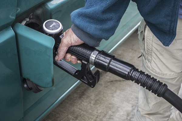 Close up of man pumping diesel fuel into his vehicle at service station