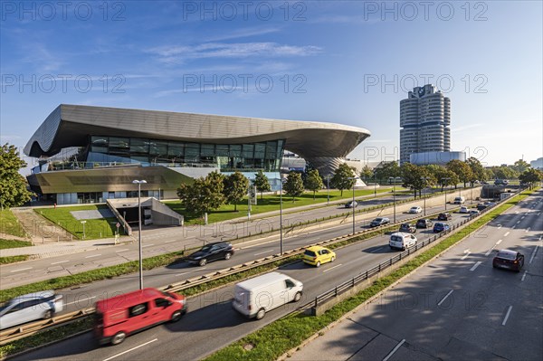 Road traffic in front of BMW Welt and the BMW four-cylinder administration building in Munich,