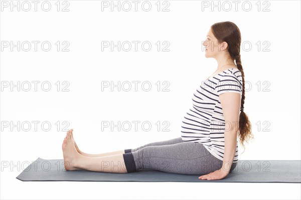 Pregnancy yoga exercise, pregnant woman doing yoga asana Dandasana Staff pose isolated on white