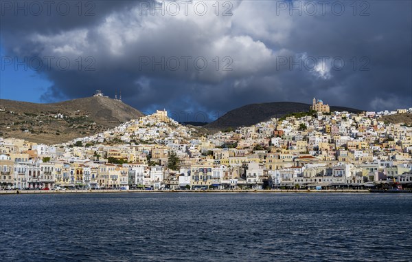 View of the town of Ermoupoli with pastel-coloured houses and sea, on the hill Anastasi Church or