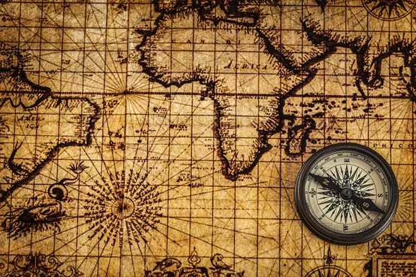 Travel geography navigation concept background, old vintage retro compass on ancient world map