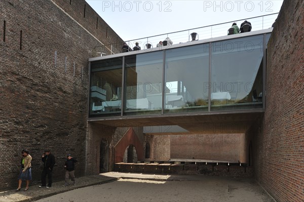 Restaurant with terrace and tourists with audio guides at Fort Napoleon in the dunes near Ostend,