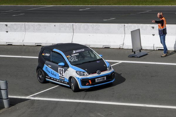 Racing car for series VW up! GTI Cup with driver Leon Arndt is marshalled into Parc Fermé by track