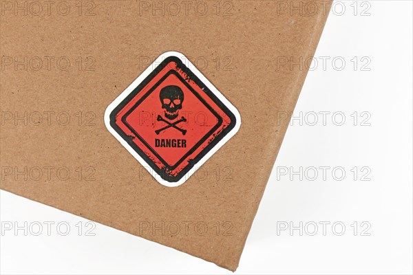 Red warning label with skull and word 'Danger' on parcel