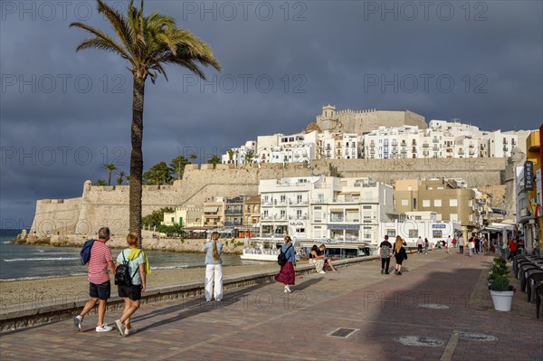 Tourists on the promenade, in the background the old town, Peñíscola, province Castellón, Costa del