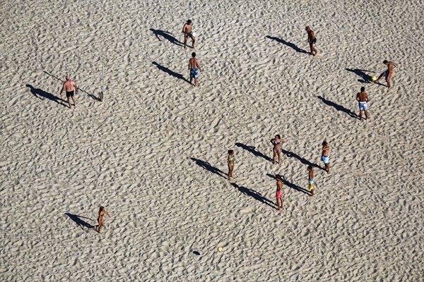 Beach volleyball on the beach of Nazaré, players cast long shadows, view from above, Portugal,