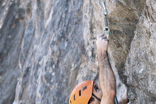 Close-up from above, rock climbing using outdoor safety harness and helmet