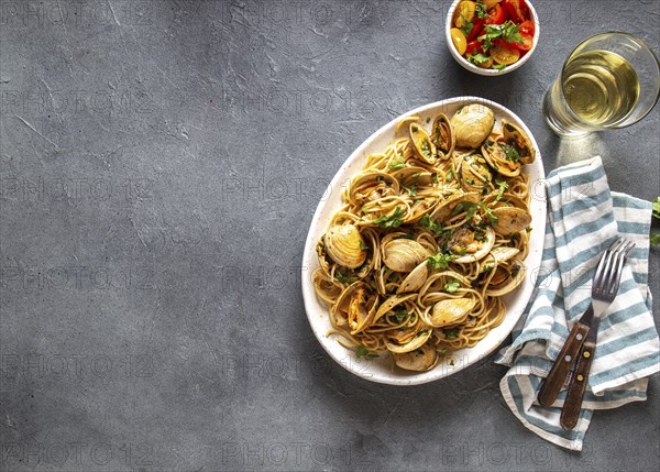Seafood Pasta. ITALIAN SPAGHETTI ALLE VONGOLE. Clams spaghetti on white plate with white wine, gray