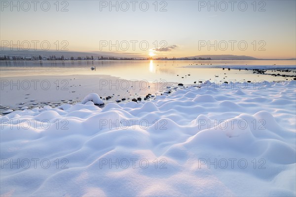 The wintery snow-covered lake with setting sun and peaceful atmosphere, Seegarten, Allensbach, Lake