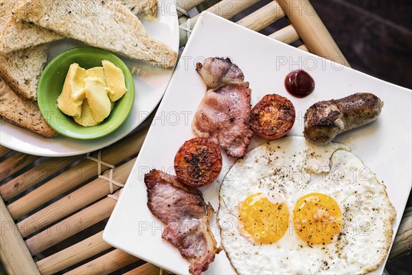 Traditional classic english british fried breakfast with eggs bacon tomato sausage and toast set