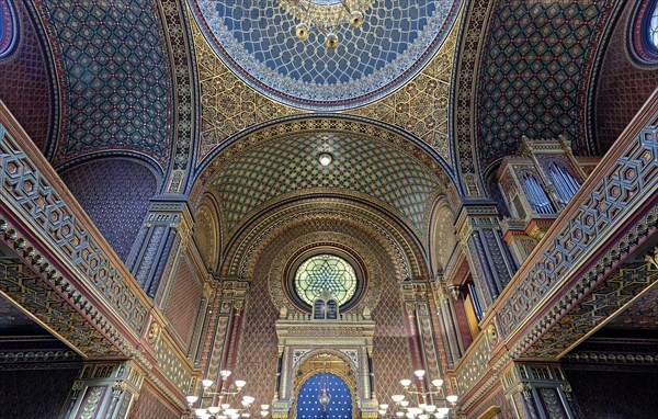 Intricate and colorful architectural details inside a large synagogue with mosaic tilework and