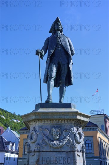 Ludvig Holberg statue on a pedestal in front of historic buildings on a sunny day, Bergen,